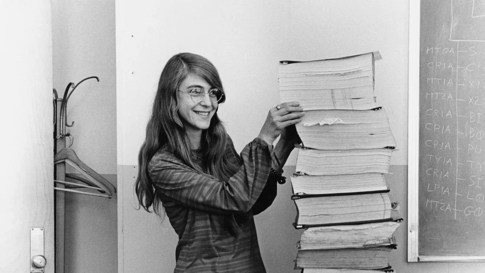 Margaret Hamilton ยืนข้างกองเอกสารพิมพ์โค้ดซอฟต์แวร์การบินของ Apollo ที่ทีม MIT พัฒนา ปี 1969