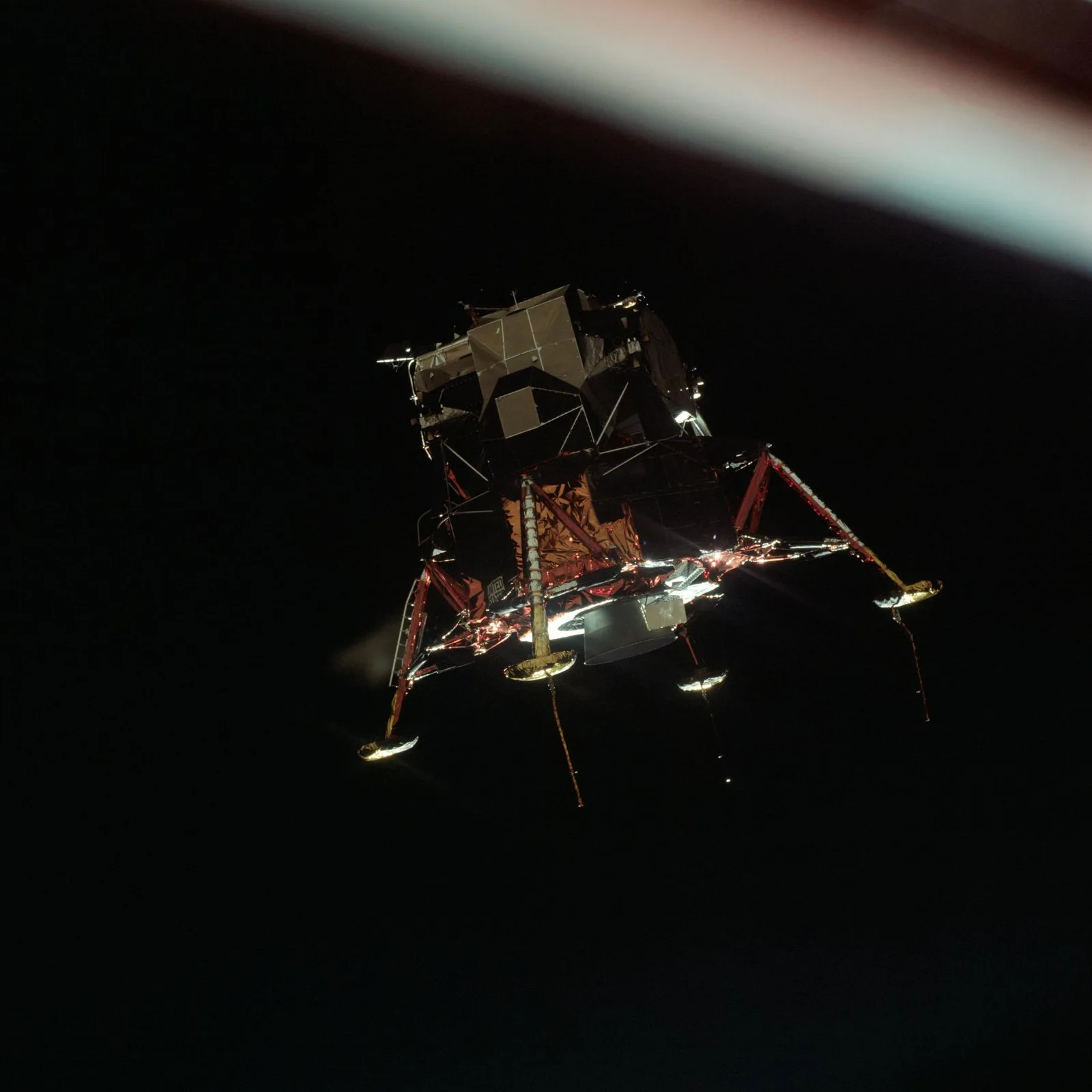 ยานลงจอด Eagle ของ Apollo 11 กางขาลงจอด ลอยอยู่ในวงโคจรรอบดวงจันทร์บนพื้นหลังอวกาศสีดำ